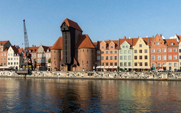 Colorful merchant houses lining the Motlawa River waterfront in Gdansk with Gothic architecture